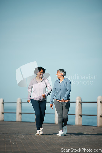 Image of Exercise, walking and senior women by ocean for healthy body, wellness and cardio on promenade. Sports, friends and happy female people in conversation on boardwalk for fitness, training and workout