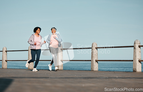 Image of Senior women, fitness and running at beach for health, wellness and exercise in nature together. Elderly, friends and ladies at sea talking, workout and active retirement, fun and bonding ocean run