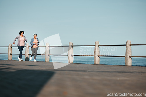 Image of Fitness, friends and senior women at the beach for exercise, health or cardio on blue sky background. Training, wellness and elderly lady runner at the sea for morning workout, routine or ocean run