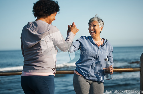 Image of Fitness, high five and senior women friends at beach with exercise, celebration and excited in nature. Sport, people and elderly females with hands in support of wellness, training or success at sea