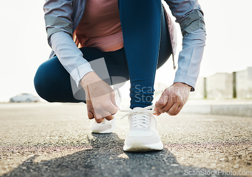 Image of Fitness, closeup and woman tie shoes outdoor in the road for running workout in the city. Sports, health and zoom of female athlete tying her laces for cardio exercise for race or marathon training.