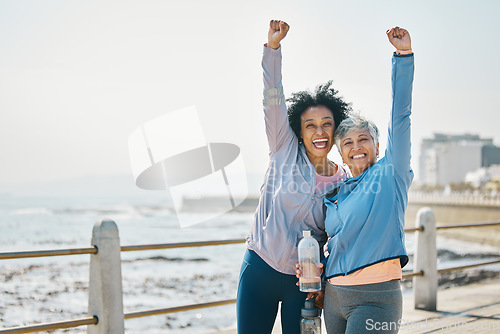 Image of Success, women and friends, fist pump and fitness goals with running outdoor, winning and health. Happy senior female people, exercise achievement while training for marathon with cheers at beach