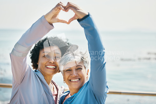 Image of Heart, hands and health with portrait of friends at beach for fitness, support and love. Motivation, happy and wellness with mature women and sign in nature for exercise, workout and emoji mockup