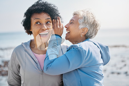 Image of Gossip, beach and senior friends with a secret, whisper or talking in ear for a funny joke after outdoor exercise. Laughing, crazy and elderly women listening to conversation or story at the sea