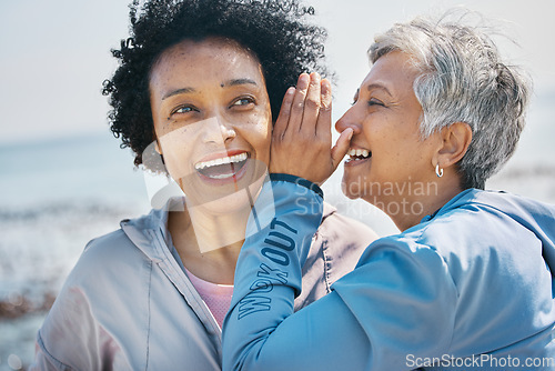 Image of Gossip, outdoor and senior friends with a secret, whisper or talking in ear for a funny joke after beach exercise. Laughing, crazy and elderly women listening to conversation or story at the sea