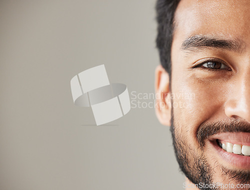Image of Half face, portrait and smile of an asian man in studio with positive mindset, wellness and awareness. Young male model isolated on grey background with happiness, mockup space and confident headshot
