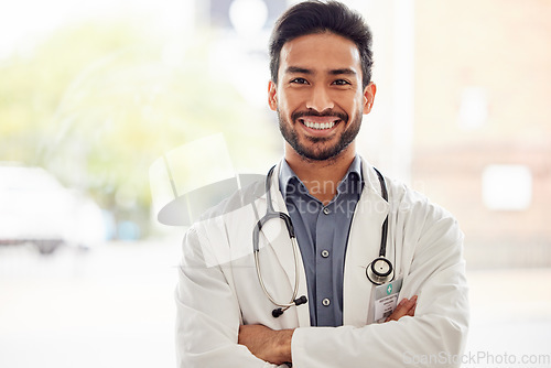 Image of Smile, portrait and asian man doctor with arms crossed in hospital for consulting, exam and help on blurred background. Happy, face and guy healthcare expert proud of service while working at clinic