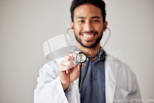 Image of Healthcare, portrait and man doctor hand holding stethoscope in studio for hospital, checkup or exam. Face, smile and male cardiovascular expert with medical tool for chest, lungs and heartbeat check