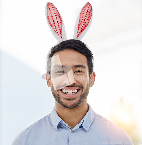 Image of Bunny ears, holiday and business man portrait with a smile from easter and creative job pride. Celebration, happy and male professional from Spain feeling silly and goofy with comedy hat at office