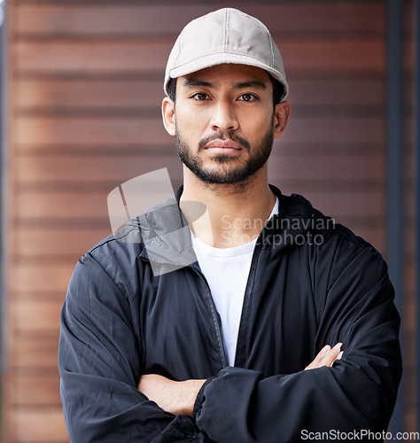 Image of Courier man, outdoor portrait and arms crossed for service, delivery and ready for supply chain. Young logistics worker, serious face and city for customer satisfaction, commerce and distribution job