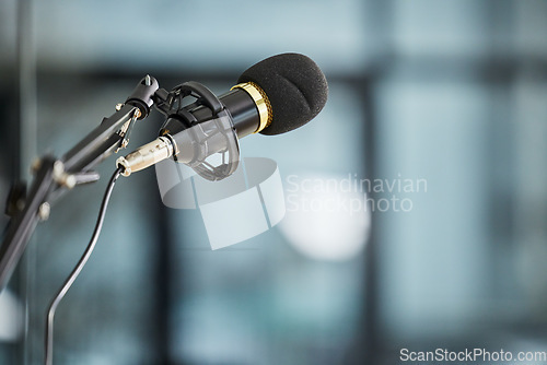 Image of Conference, auditorium and microphone in an office for a speech, work event or presentation. Bokeh, business and a mic or gear for a meeting, workshop speaker or a corporate seminar at the workplace