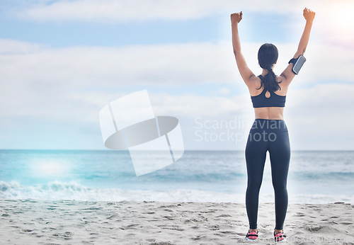 Image of Fitness, celebration and woman with arms up at beach, mockup and winning achievement in nature. Ocean, goals and exercise girl for workout motivation, victory and blue sky with waves in natural space