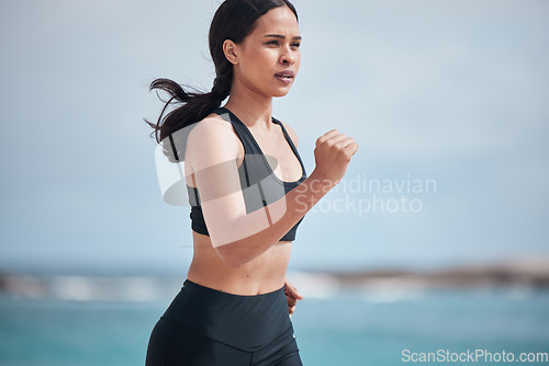 Image of Running, exercise and woman at a beach for fitness, training and body performance workout for healthy energy. Sports, wellness and female runner at the sea for resilience, challenge or ocean run