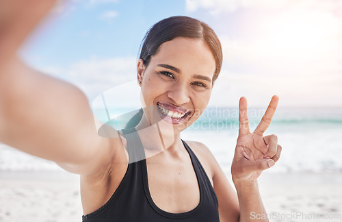 Image of Exercise, selfie and woman at beach with peace hands for running, sports or fitness in nature. Portrait, happy and lady health and wellness influencer smile for social media, blog or profile picture