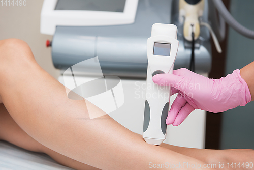 Image of Specialist makes skin tone measurements on a womans leg