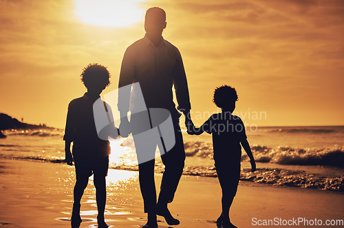Image of Silhouette, sunset and father holding hands with children at the beach for walking, bonding and vacation. Dark, care and dad with kids at the ocean for a walk, travel and quality time together