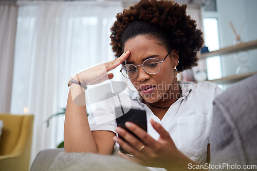 Image of Woman, stress and reading phone in home for notification of bad news, problem and crisis of mistake on social media. Confused african female person with anxiety, doubt and frustrated with mobile scam