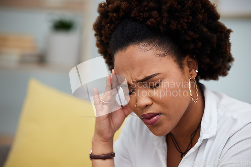 Image of Woman, headache and stress in debt, financial crisis or burnout on sofa at home. Face of African female person with bad head pain, migraine or mental health strain from pressure or difficulty