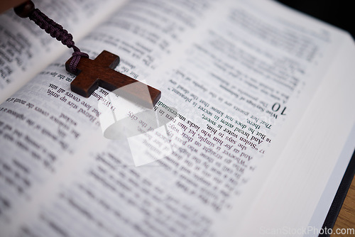 Image of Background, christian and rosary on bible book for praying, spiritual faith or holy worship to God in heaven. Closeup of cross for studying religion, reading prayer or scripture story of Jesus Christ