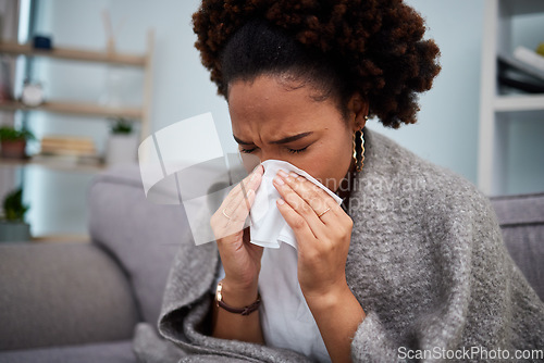 Image of Sick, couch and woman in a blanket with flu at home, house or apartment with a cold, fever and blowing nose. Virus, sad and female person with a tissue ill on sofa in a lounge with a medical problem