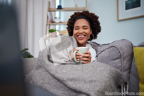 Image of Laptop, coffee and woman with blanket on sofa laughing for comedy, funny and comic movies. Happy, home and African female person relax with computer for entertainment, streaming and watching film