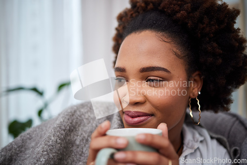 Image of Relax, coffee and thinking with woman in living room for peace, happy and morning. Health, happiness and drinking tea with African person smile on sofa at home for caffeine, beverage and free time