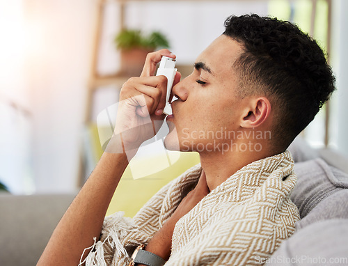 Image of Asthma, sofa and person with inhaler due to cold, flu and fever in a home living room with a blanket on couch. Healthcare, medical and young with difficult symptoms and sick in a house lounge