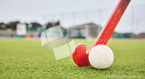 Image of Field, sports and a ball and a stick for hockey, fitness and training in the morning. Closeup, ground and gear or equipment for a competition, game or tournament at a stadium or turf on bokeh