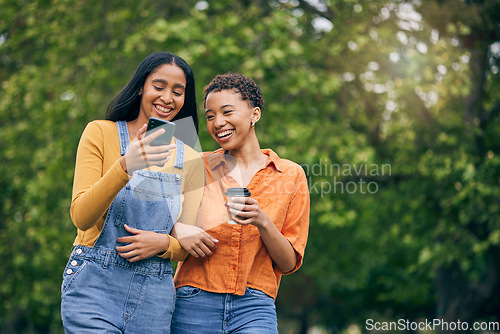 Image of Phone, friends and women in park with coffee together for holiday, bonding and quality time outdoors. Friendship, happy and female people walking in nature for relaxing, conversation and social media