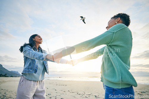 Image of Holding hands, happy and a lesbian couple at the beach for trust, love and care on a holiday. Smile, summer and lgbt women with freedom, support and love at the sea on a date, vacation or together