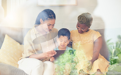 Image of Tablet, gay family and child on a home sofa for internet, streaming and e learning. Adoption, lesbian or LGBT women or parents and a kid together in a living room with tech for game, app or video