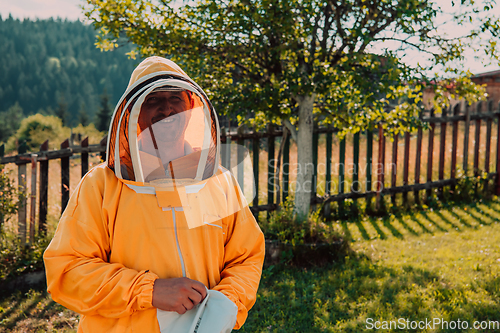 Image of Beekeeper put on a protective beekeeping suit and preparing to enter the apiary