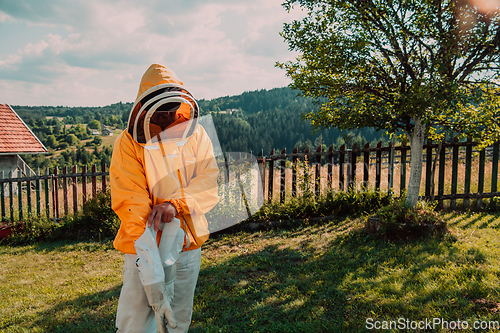 Image of Beekeeper put on a protective beekeeping suit and preparing to enter the apiary