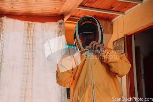 Image of Beekeeper put on a protective beekeeping suit and preparing to enter the apiary