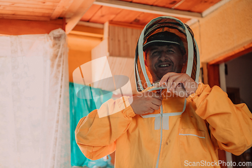 Image of Beekeeper put on a protective beekeeping suit and preparing to enter the apiary