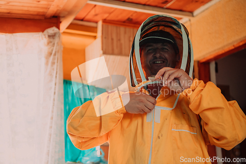 Image of Beekeeper put on a protective beekeeping suit and preparing to enter the apiary