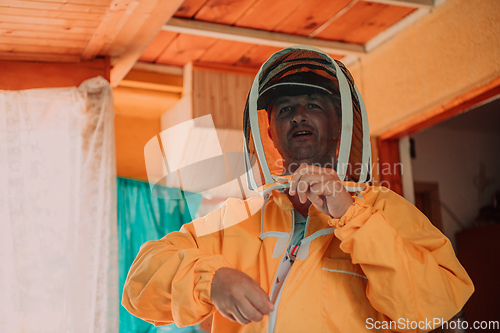 Image of Beekeeper put on a protective beekeeping suit and preparing to enter the apiary