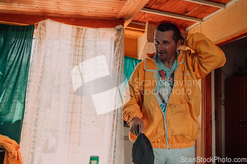 Image of Beekeeper put on a protective beekeeping suit and preparing to enter the apiary