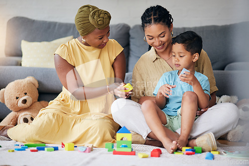 Image of Toys, child and a gay family playing on a home floor for development, education and learning. Adoption, lesbian or LGBT women or parents and kid together in a lounge for quality time with fun blocks