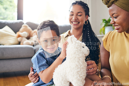 Image of Portrait, gay family and child with a teddy bear on a home floor for development, fun and smile. Adoption, lesbian or LGBT women or parents and kid together in a lounge while playing with toys