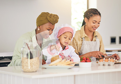 Image of Gay family, child and cooking in home kitchen for learning, development and love. Adoption, lesbian or lgbtq women or parents and a happy young kid together to cook breakfast food with care and help