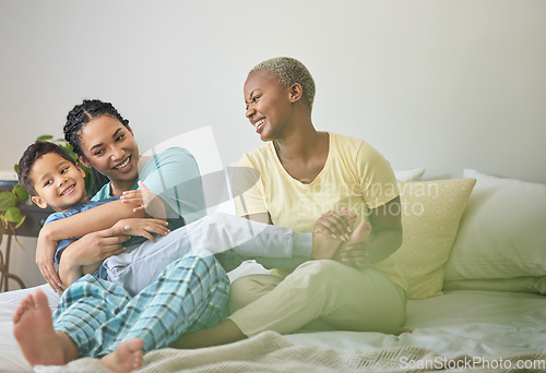 Image of Morning, gay family and hug on bed in home bedroom for security, quality time and love. Adoption, lesbian or LGBTQ women or parents and a happy foster kid together to wake up with care and fun play