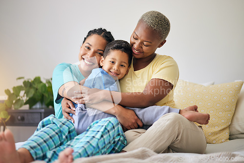 Image of LGBT, bedroom hug and family portrait, happy child and mothers bond, relax and enjoy time together. Home, bed and gay people, queer parents or lesbian women support, care and hugging adoption kid