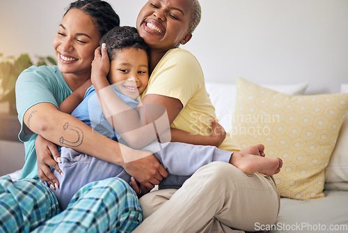 Image of LGBT, bedroom hug and happy family, child and relax mothers bonding, support and enjoy quality time together. Home, care and gay people, homosexual parents or lesbian women embrace young kid on bed