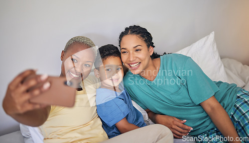 Image of Gay, happy family and selfie in bed with foster boy child and relax at home. Adoption, lesbian couple and lgbt women on social media, smile for profile picture, blog or post in bedroom on the bed