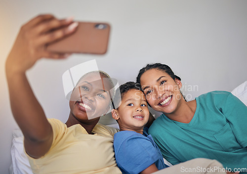 Image of Gay family, happy and selfie in bed with foster boy child, bond and relax at home. Adoption, lesbian women and social media lgbt influencer smile for profile picture, blog or podcast post in bedroom