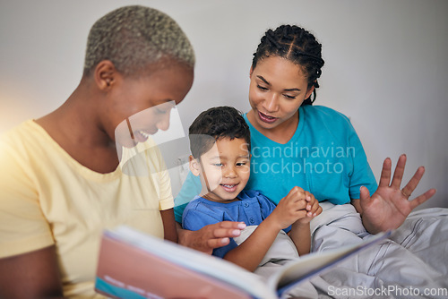 Image of Reading, LGBT family and child with a book in bed for knowledge, education and learning. Adoption, lesbian or gay women or parents and foster kid together in home bedroom with story for quality time