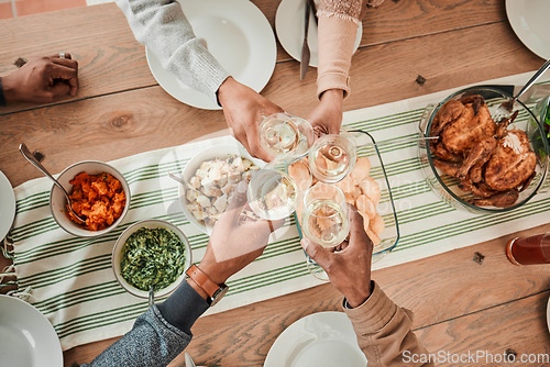 Image of Wine, food and toast with hands of family at dining table for party, celebration and holiday from above. Lunch, cheers and success with closeup of people and at home for event, support and dinner