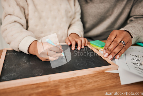 Image of Hands, writing and mom with child on home, table for remote learning, education or drawing on chalkboard or desk in house. Helping, teaching and creative kid with chalk and support from parent