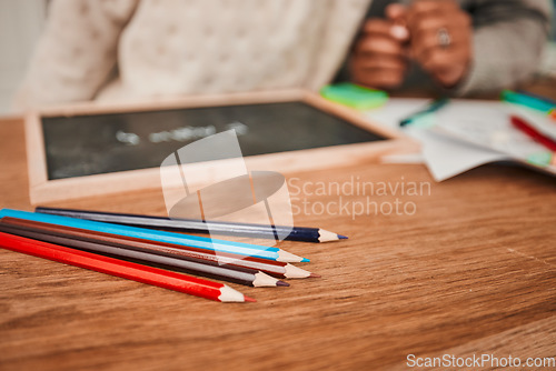 Image of Hands, helping and child with pencils on table for remote learning, education or writing on board, paper or desk in house. Closeup, drawing and creative kid working on art with parent in home